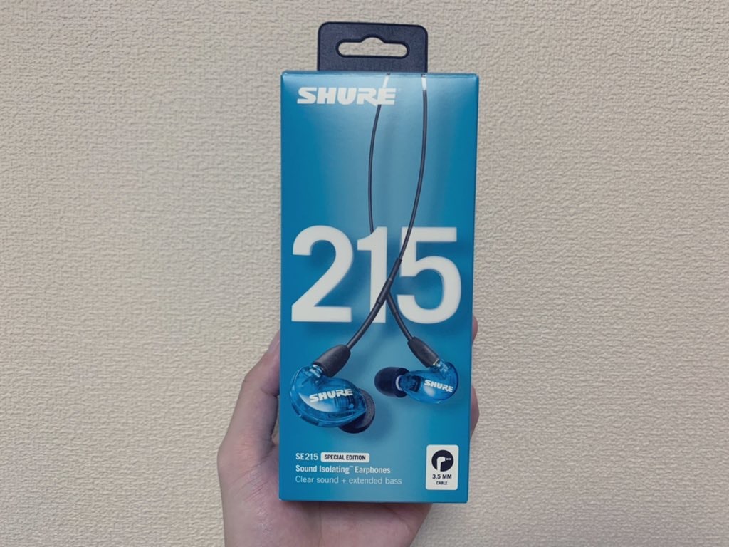 SHURE の『SE215』というイヤホンの外箱の写真。青い箱で、イヤホン自体も青色。